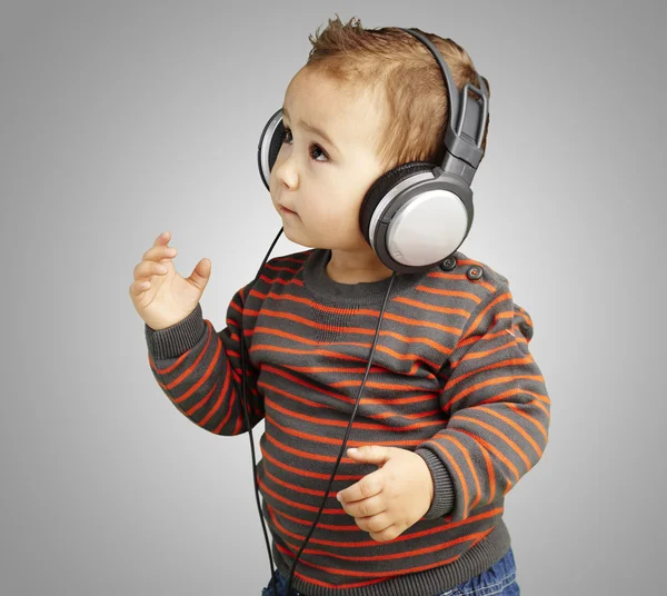 Retrato de niño adorable con auriculares escuchando música agai — Foto de Stock