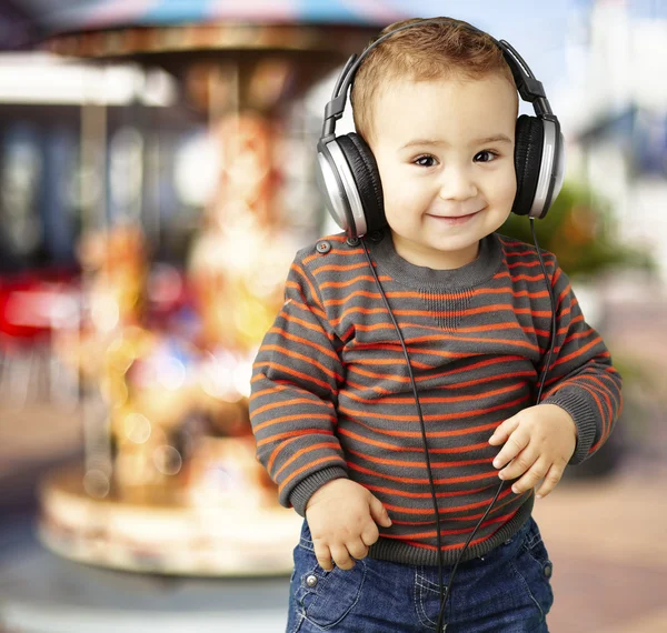 Πορτρέτο του ένα όμορφο παιδί ακούγοντας μουσική και χαμογελαστός εναντίον — Φωτογραφία Αρχείου