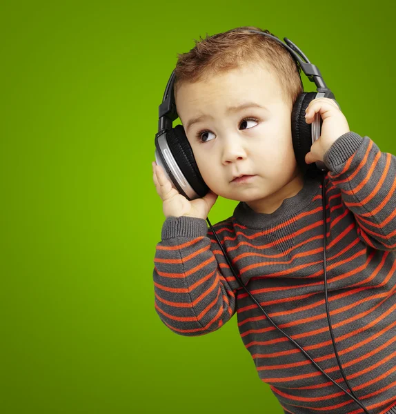 Porträtt av en stilig barn lyssnar på musik titta upp över gr — Stockfoto