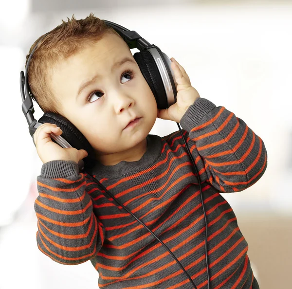 Πορτρέτο του ένα όμορφο παιδί ακούγοντας μουσική κοιτώντας ψηλά εσωτερική — Φωτογραφία Αρχείου