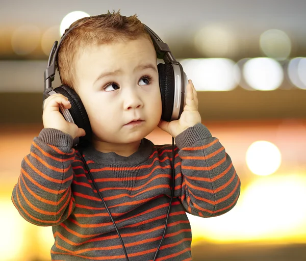 Портрет красивого ребенка, слушающего музыку с видом на город — стоковое фото