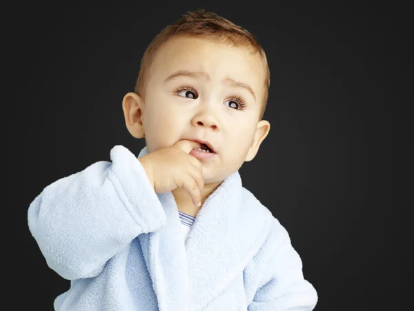 Retrato de un niño adorable con el dedo en la boca usando —  Fotos de Stock