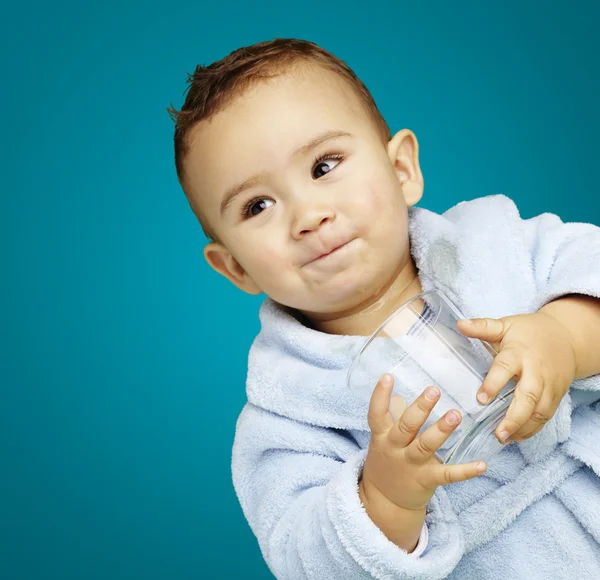 Retrato de un niño adorable con albornoz azul sosteniendo un vaso o —  Fotos de Stock