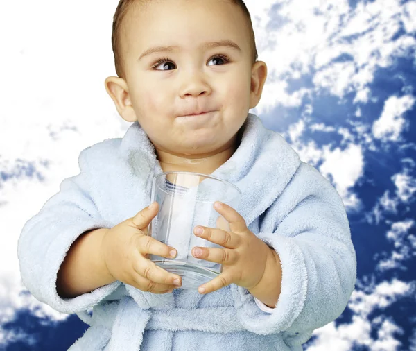 Porträt eines entzückenden Säuglings mit blauem Bademantel, der ein Glas hält — Stockfoto