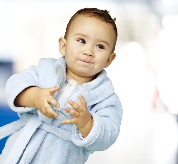 Retrato de adorable infante con albornoz azul sosteniendo un vaso i — Foto de Stock