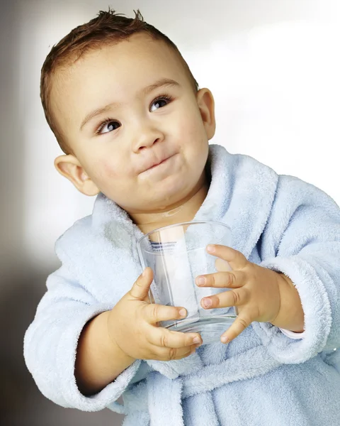Portrait of adorable infant with blue bathrobe holding a glass i — Stock Photo, Image