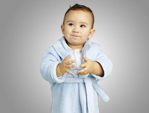 Retrato de un niño adorable con albornoz azul sosteniendo un vaso o — Foto de Stock