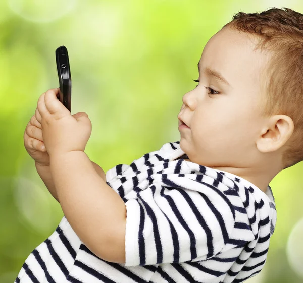 Lustiges Kind berührt Handy im Park — Stockfoto