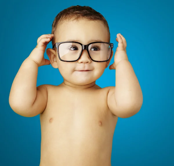 Porträtt av funny kid bar överkropp bär glasögon över blå bakgrunds — Stockfoto