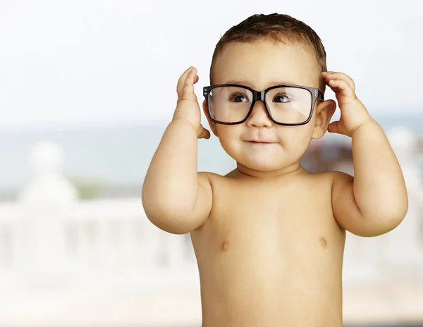 Retrato de criança engraçada sem camisa usando óculos perto da praia — Fotografia de Stock