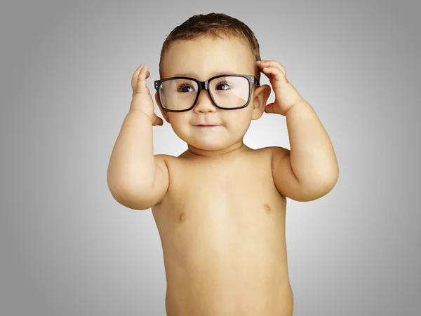 Retrato de criança engraçada sem camisa usando óculos sobre backgr cinza — Fotografia de Stock
