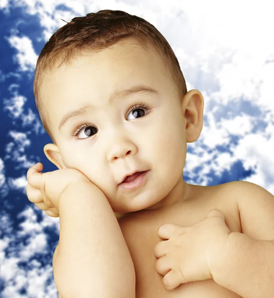 Retrato de un niño adorable posando sobre un fondo nublado —  Fotos de Stock