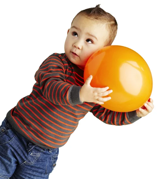 stock image Portrait of funny kid holding a big orange balloon over white ba