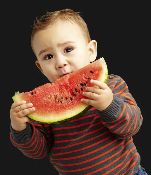 Porträtt av stilig liten innehar en vattenmelon över svart backg — Stockfoto