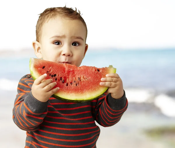 Porträtt av stilig liten innehar en vattenmelon nära havet sho — Stockfoto