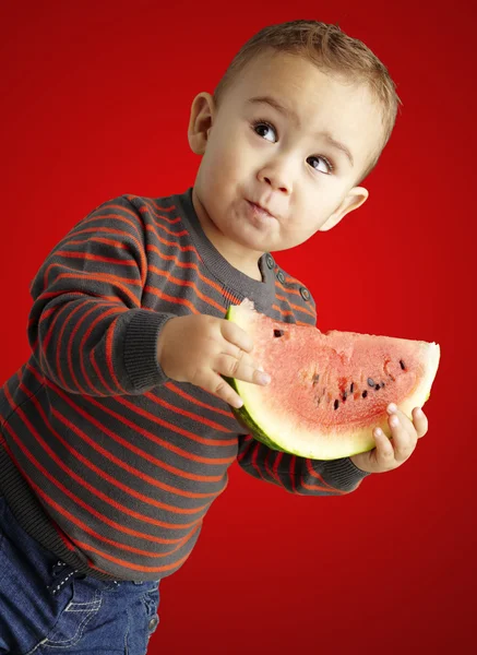Porträt eines hübschen Kindes, das eine Wassermelone in der Hand hält und — Stockfoto
