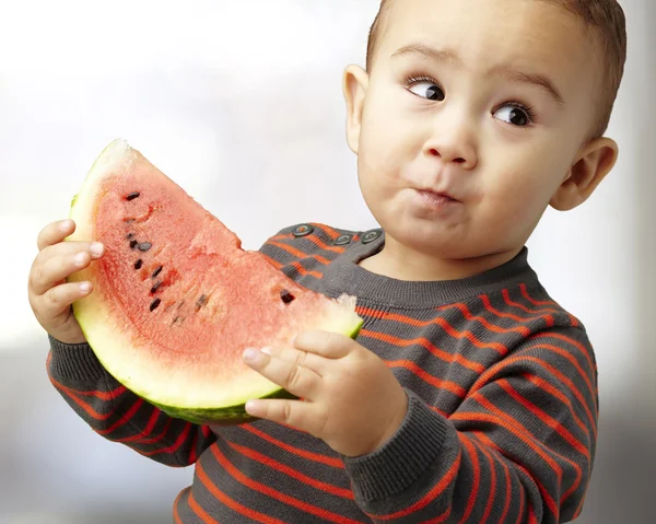 Porträt eines schönen Kindes, das eine Wassermelone in der Hand hält und Indo probiert — Stockfoto