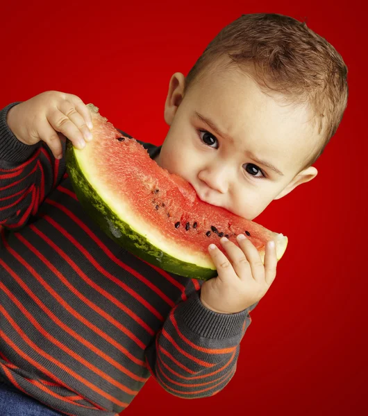 Porträt eines hübschen Kindes, das eine Wassermelone in der Hand hält und darüber saugt — Stockfoto