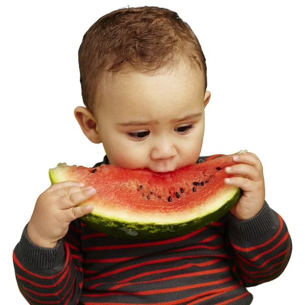 Porträt eines hübschen Kindes, das eine Wassermelone über einem weißen Backgr beißt — Stockfoto