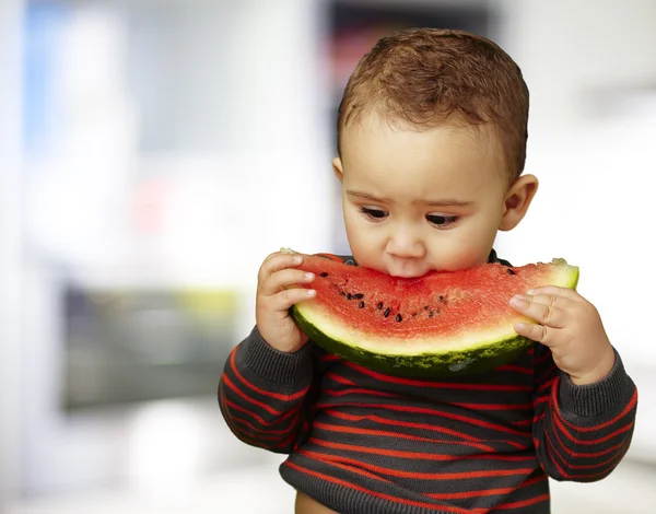 Porträtt av en stilig kid håller i en vattenmelon och suckin — Stockfoto
