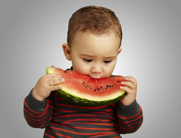Porträtt av en stilig kid hålla en vattenmelon och sugande över — Stockfoto
