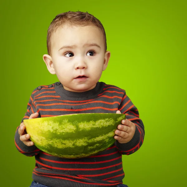Portrét dítě drží velký meloun nad zeleným poza — Stock fotografie