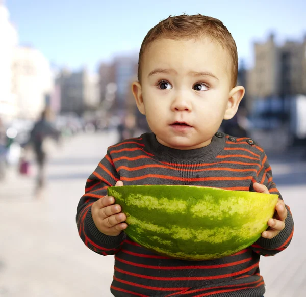 Porträt eines süßen Kindes mit einer großen Wassermelone in der Hand — Stockfoto