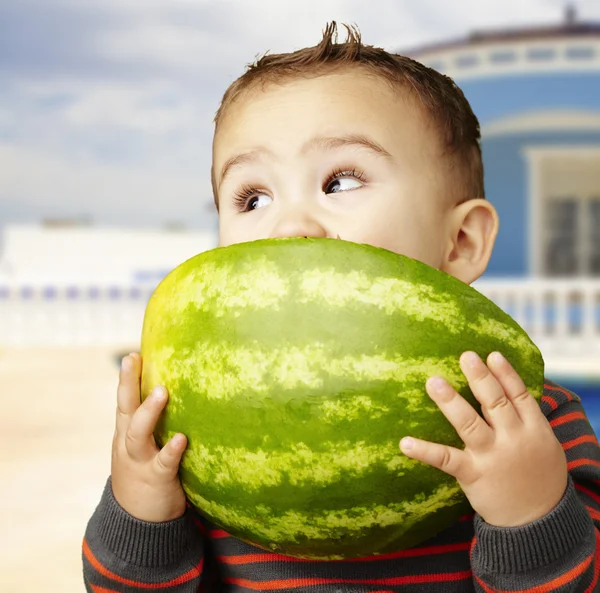 Porträt eines hübschen Kindes, das Wassermelone in der Hand hält und an hou saugt — Stockfoto