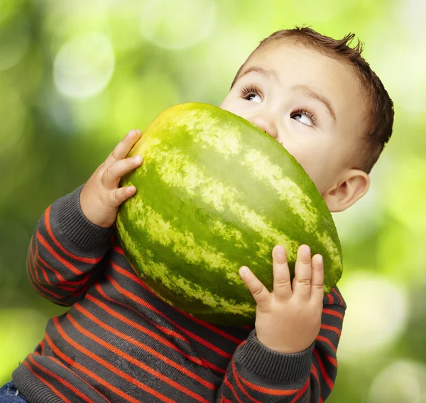 Retrato de um garoto bonito segurando melancia e chupando agains — Fotografia de Stock