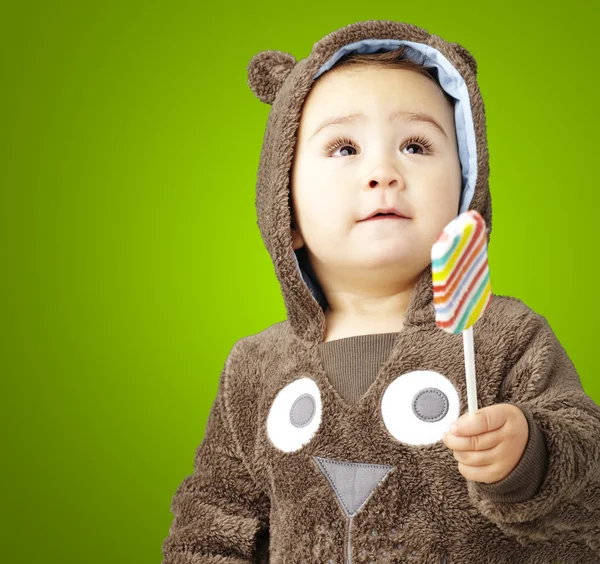 Retrato de um garoto bonito vestindo um urso marrom suéter holdi — Fotografia de Stock