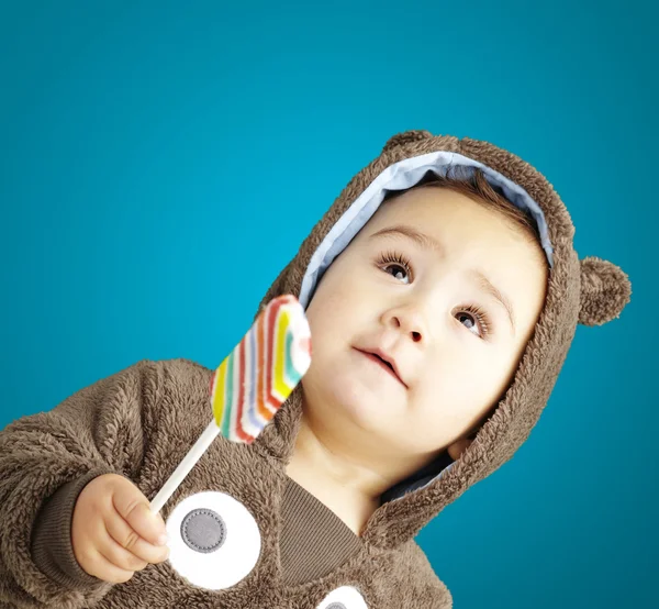 Portrait of a handsome kid wearing a brown bear sweatshirt holdi — Stock Photo, Image