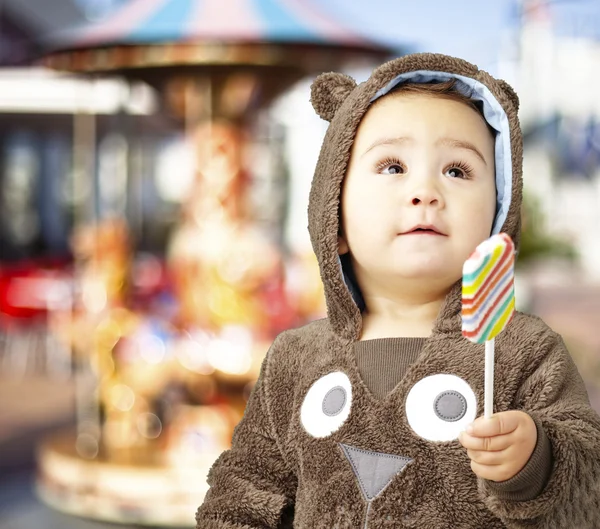 Retrato de um garoto bonito vestindo um urso marrom suéter holdi — Fotografia de Stock
