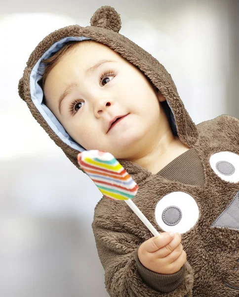Portrait of a handsome kid wearing a brown bear sweatshirt holdi — Stock Photo, Image