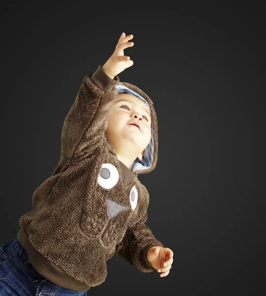 Portrait of young man raising the arm against a black background — Stock Photo, Image