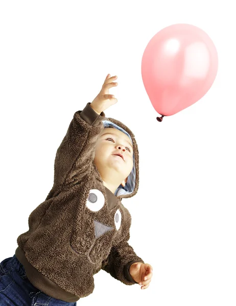 Retrato de un chico gracioso tratando de sostener un globo rosa sobre blanco b — Foto de Stock