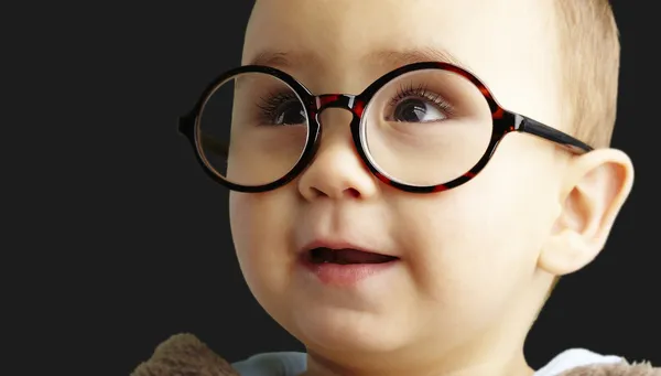 Retrato de niño dulce con gafas redondas sobre fondo negro — Foto de Stock
