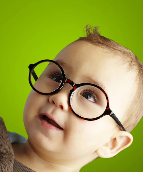 Portrét sladké dítě nosí kulaté brýle přes zelené poza — Stock fotografie