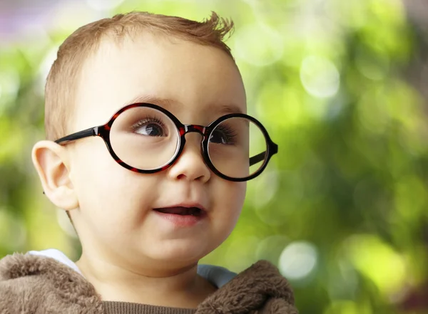 Portrait of kid wearing round glasses against a nature backgroun — Stock Photo, Image