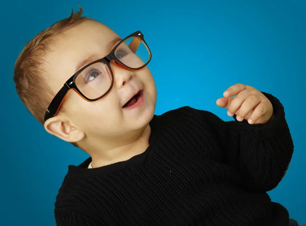 Retrato de criança adorável vestindo óculos e gesticulando sobre azul — Fotografia de Stock