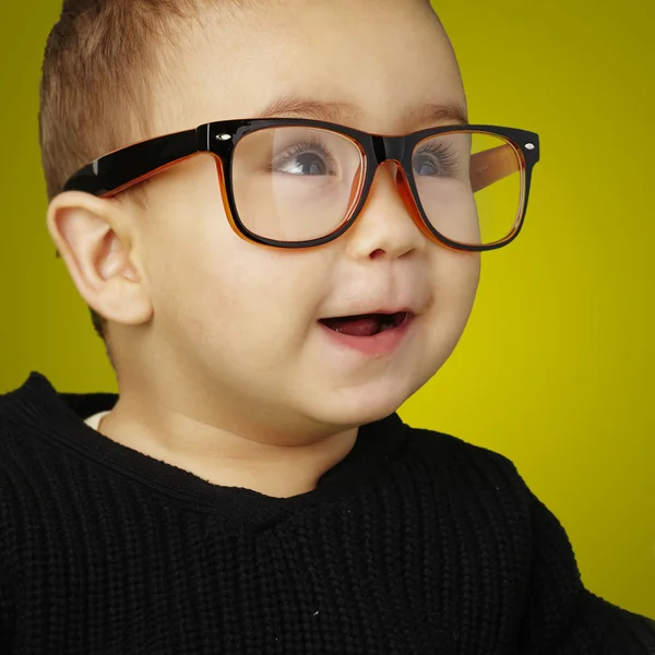 Porträt eines entzückenden Kindes mit Brille auf gelbem Hintergrund — Stockfoto