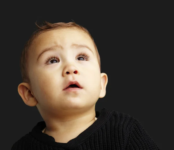 Porträtt av en stilig unge tittar upp mot en svart bakgrund — Stockfoto