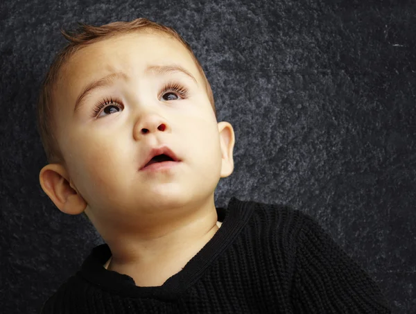 Porträt eines gutaussehenden Kindes, das gegen eine Grunge-Wand blickt — Stockfoto