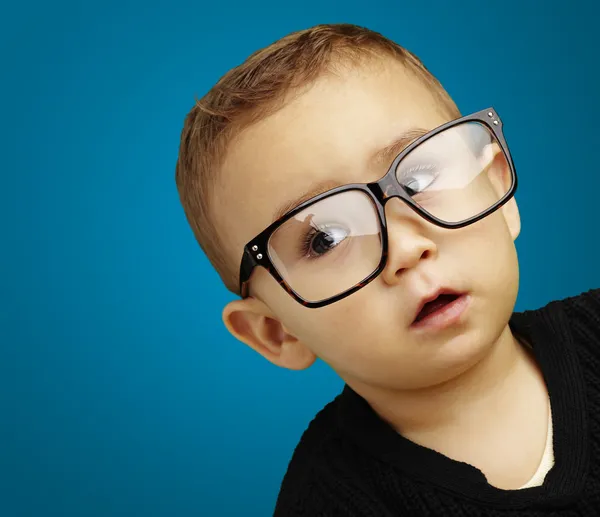 Mavi arka plan üzerinde gözlüklü çocuk portresi — Stok fotoğraf
