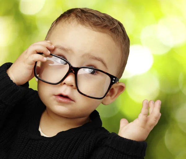 Portret dziecka w okularach i patrząc w parku — Zdjęcie stockowe