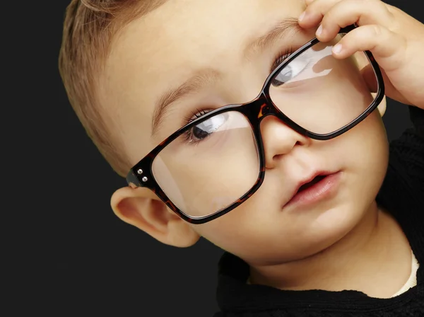 Portrait d'un enfant sérieux portant des lunettes et faisant un geste sur — Photo