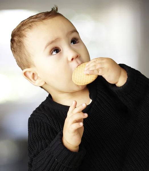 Yakışıklı çocuk kapalı bisküvi yeme portresi — Stok fotoğraf