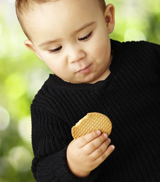 Doğa backg karşı bisküvi yeme yakışıklı çocuk portresi — Stok fotoğraf