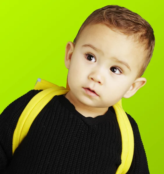 Portret van schattige jongen uitvoering geel rugzak over groene bac — Stockfoto