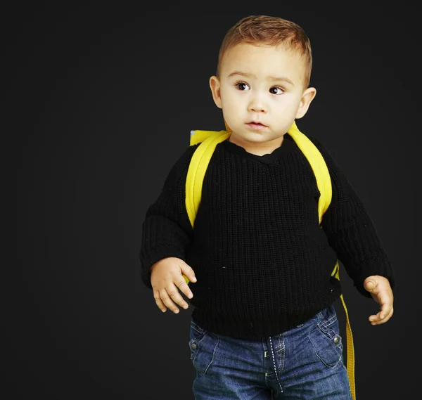 Portrait of adorable kid carrying yellow backpack over black bac — Stock Photo, Image