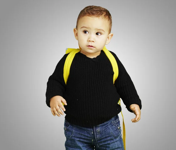 Retrato de criança adorável carregando mochila amarela sobre cinza de volta — Fotografia de Stock